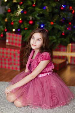 Pembe elbiseli şömine TH yakın oturan bir sevimli genç kız