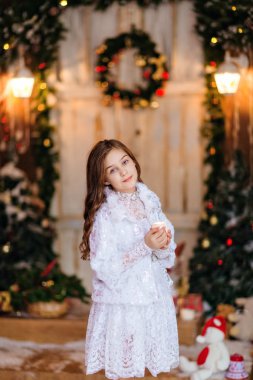 sevimli uzun saçlı kız ayakta, holding ben beyaz bir elbise