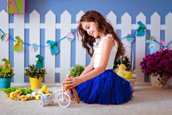 Muito bonito menina de cabelos longos em uma saia azul sentado no — Fotografia de Stock