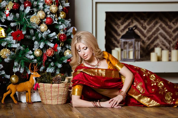 Мбаппе и чувственная блондинка в индийском красном Сари, лежащая на полу — стоковое фото