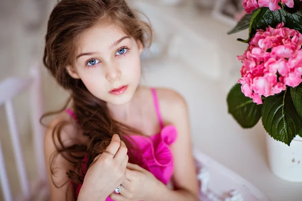 Porträtt av söt baby flickor med vackra hår i en rosa klänning i — Stockfoto