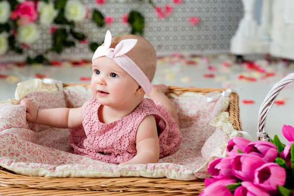 Malé velmi roztomilé, big-eyed holčička v růžových šatech, ležící v — Stock fotografie