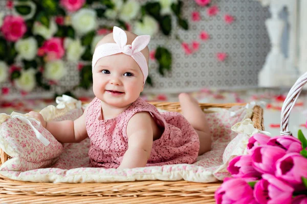 Piccolo molto carino dagli occhi larghi sorridente bambina in un abito rosa lyin — Foto Stock