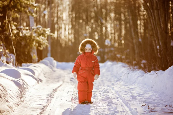 Μικρό πολύ χαριτωμένο κορίτσι σε ένα κόκκινο κοστούμι με χειμώνα κουκούλα γούνα εν μέσω της — Φωτογραφία Αρχείου
