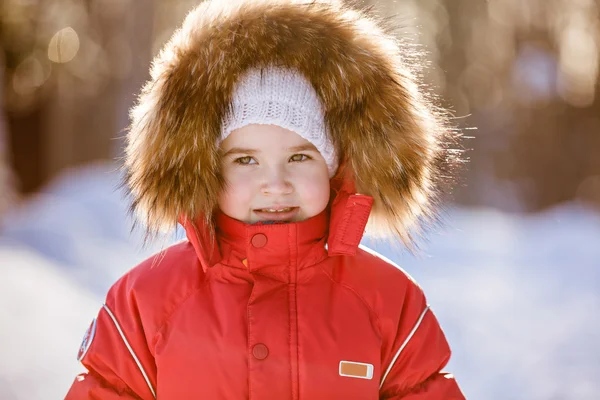 Pequena menina muito bonito em um terno vermelho com inverno capuz de pele no b — Fotografia de Stock