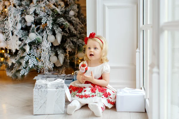 Little girl charming blonde, smiling and sitting on the floor ag