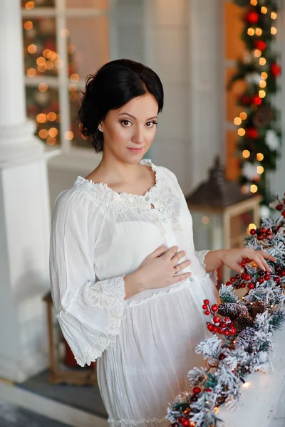 Portrait of brunette girl in anticipation of the baby in a white — Stock Photo, Image