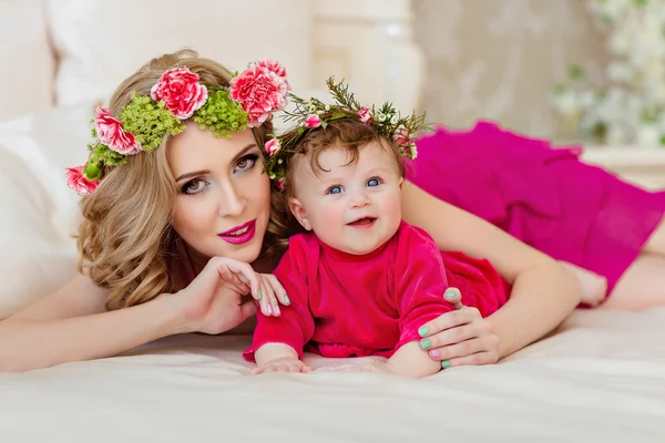 Красивая стройная блондинка мама в красном платье и венок из цветов — стоковое фото