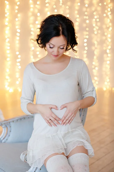 Πορτρέτο του έγκυος γυναίκα μελαχρινή σε ένα λευκό φόρεμα σε το inte — Φωτογραφία Αρχείου