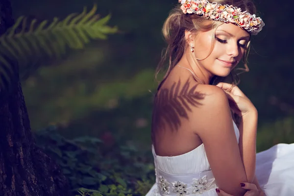 Retrato de uma bela noiva com um diadema de flores no ele — Fotografia de Stock