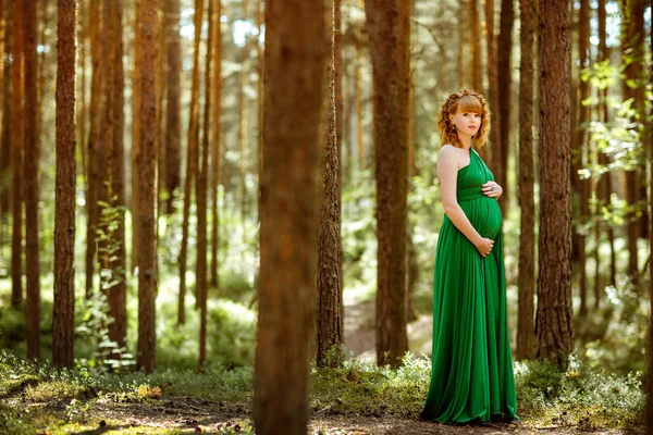 Retrato de uma bela menina grávida de cabelos encaracolados no verde — Fotografia de Stock