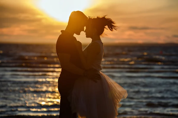 Silhouettes of men and women in the lush short skirt, kissing ag — Stock Photo, Image