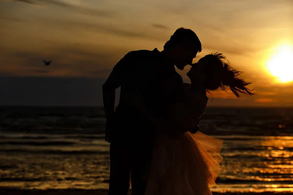 Silhuetas de homens e mulheres na exuberante saia curta, beijando ag — Fotografia de Stock