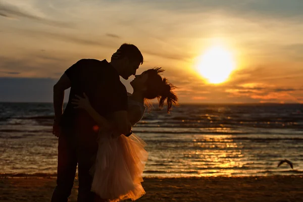 Silhuetas de homens e mulheres na exuberante saia curta, beijando ag — Fotografia de Stock