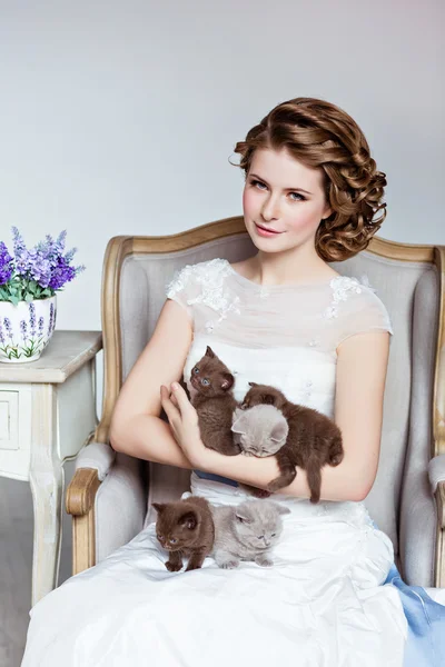 Encantadora y hermosa chica en vestido blanco sentado en una silla, s — Foto de Stock