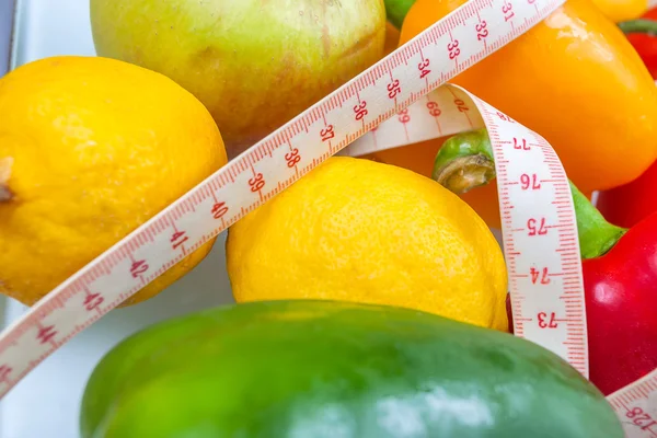 Biber, domates, elma ve limon çatal ve t ile bir ölçekte