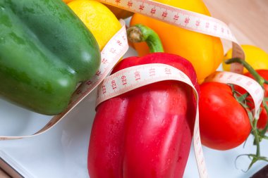 Biber, domates, elma ve limon çatal ile bir ölçekte ve 