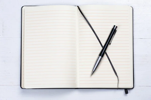 白いメモ帳ノート ラインのエレガントなペンの木製の背景 — ストック写真