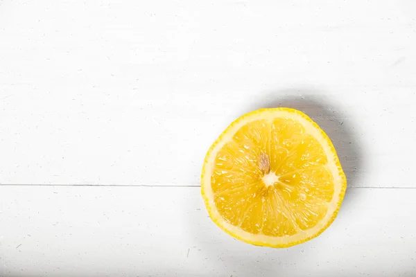 Medio limón amarillo soleado fondo de madera natural blanco — Foto de Stock