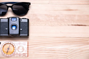 Güneş gözlüğü, vintage kamera ve bir ışık üzerine bir pusula 