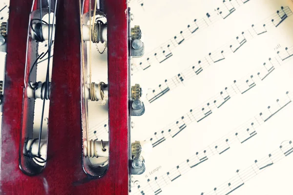 Guitar head on a music notes. — Stock Photo, Image