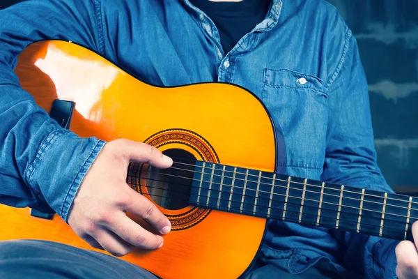 Ung man spelar på en gitarr. — Stockfoto