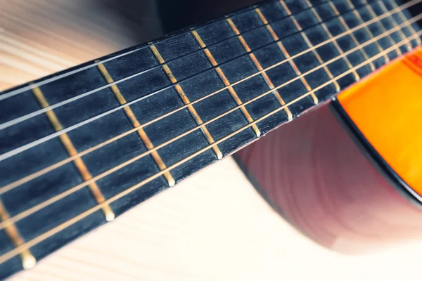 Hals, strängar, resonanslåda av en gul och orange gitarr. — Stockfoto