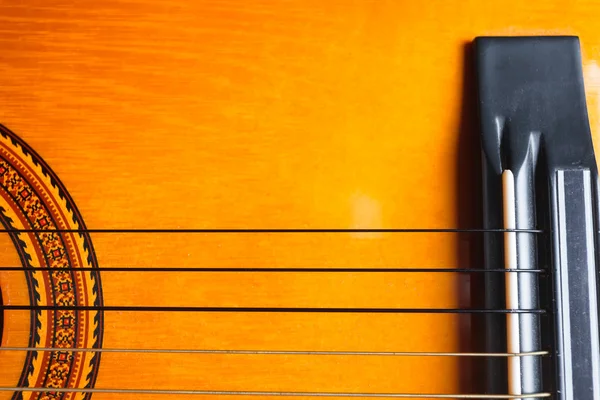 Rose, strings and bridge of a yellow and orange guitar. — Stock Photo, Image