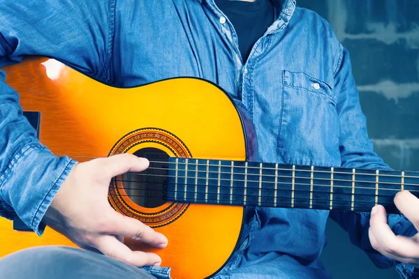 Ung man spelar på en gitarr. — Stockfoto