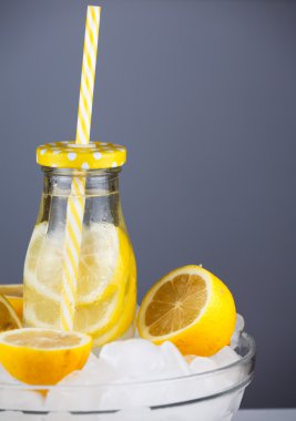 Limonata içmek trendy şişe buzda saman ile.