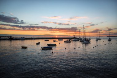 Ön planda teknelerle şaşırtıcı günbatımı