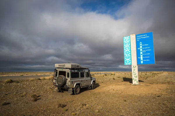 Coche aparcado delante de la señal a la Patagonia —  Fotos de Stock