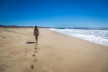 boş Beach'te yürüyen kadın
