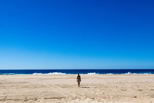 Junge Frau spaziert in leerem Strand — Stockfoto