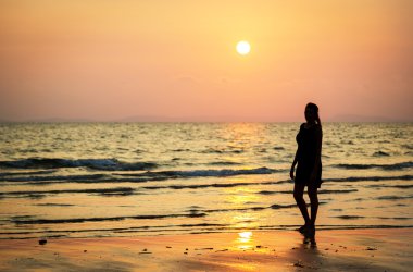 Young woman observing colourful sunset
