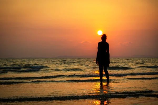 Junge Frau beobachtet farbenfrohen Sonnenuntergang — Stockfoto