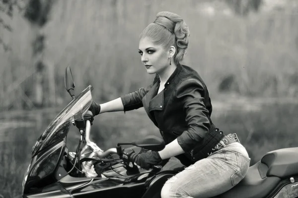 Portrait of girl on bike,motorbike.Professional blonde biker.Professional biker,blonde biker girl.Stunning biker with black leather jacket.Beautiful,attractive,pretty,nice,stunning girl sit on black bike, motorcycle.Serious,calm teenegaer,bike,motor. — 图库照片