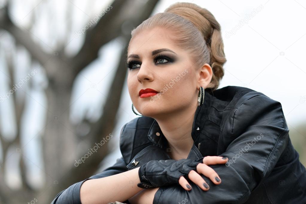 Fashionable biker girl with big green eyes,smokey makeup eyes,red big   of abrupt professional make-up for fashionable  girls, girl with rocker style looks afar,attractive girl,blonde  with beautiful make-up looks aside ...