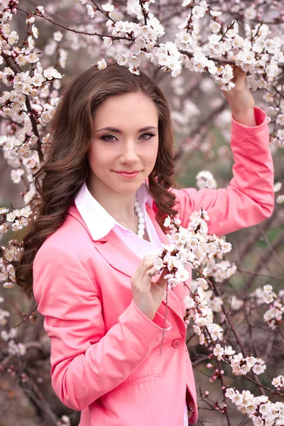 Ragazza molto bella in alberi in fiore in primavera giardino.Primavera time.Very bella, impressionante, splendida, bella ragazza con acconciatura perfetta, giacca rosa in primavera fioritura parco con molti fiori bianchi.Carino . — Foto Stock