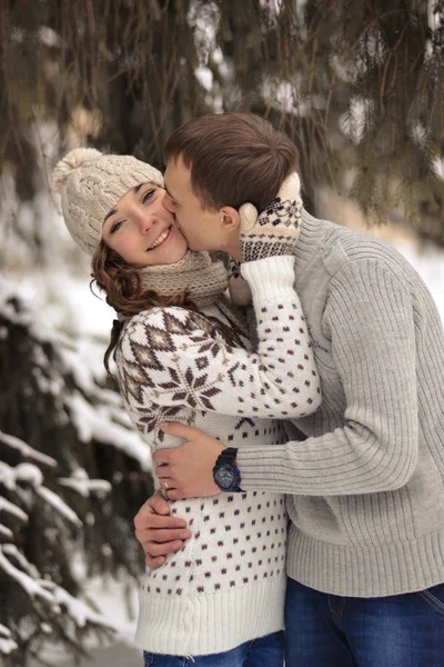 Mujer feliz, besada por su novio en el bosque. Hombre guapo besar a su amada, enamorada, atractiva, alegre, chica sonriente en la mejilla de rosa. Amantes . —  Fotos de Stock