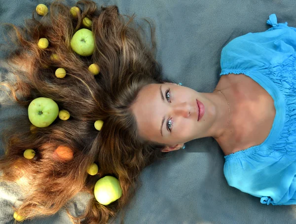 El estilo de vida saludable y la comida saludable es una promesa de una buena figura y éxito. Manzanas amarillas en un cabello grueso, ondulado y saludable . — Foto de Stock