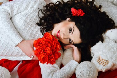 Very beautiful, nice, creative, lovely, attractive, delightful, adorable, wonderful, fashionable, glamorous brunette girl with dark, curly hair and beautiful bouquet of red roses. Holiday St. Valentine's Day.