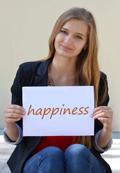 Piękna blondynka z napisem na białym papierze "Happiness". — Zdjęcie stockowe