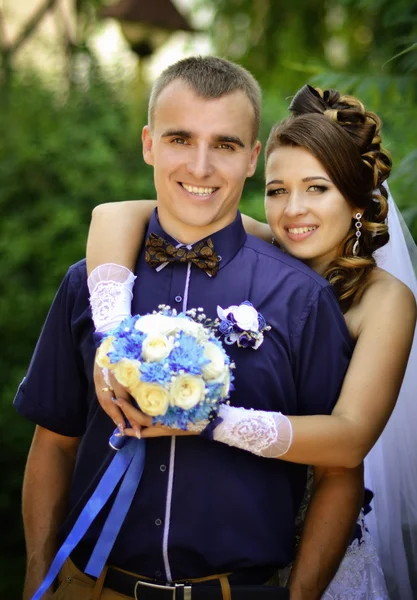 Feliz, sonriente, nueva familia joven en la boda day.Wedding amor. Boda y boda style.Beautiful novia con ramo de flores blancas y azules abrazo, abrazar a un novio . — Foto de Stock