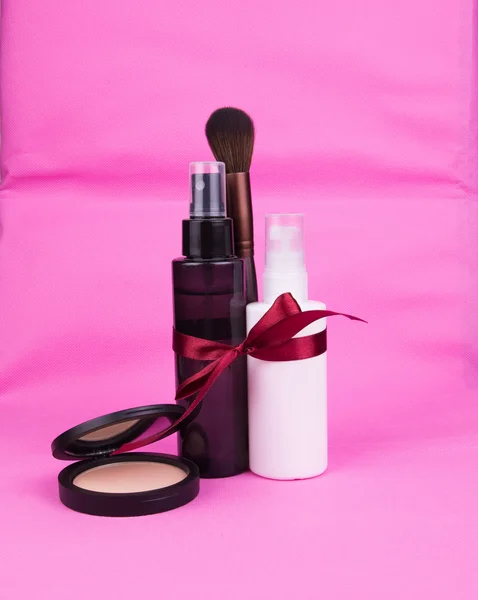 Garrafa de kit de cosméticos para presente com fita e pó em bac rosa — Fotografia de Stock