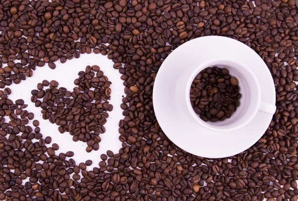 Granos de café en la taza sobre fondo blanco — Foto de Stock