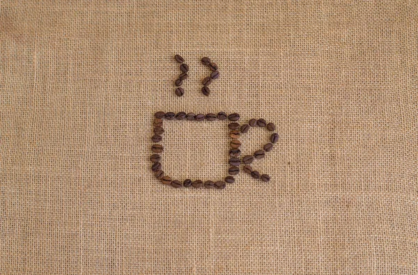 Coffee cup image made up of coffee beans on burlap background — Stock Photo, Image