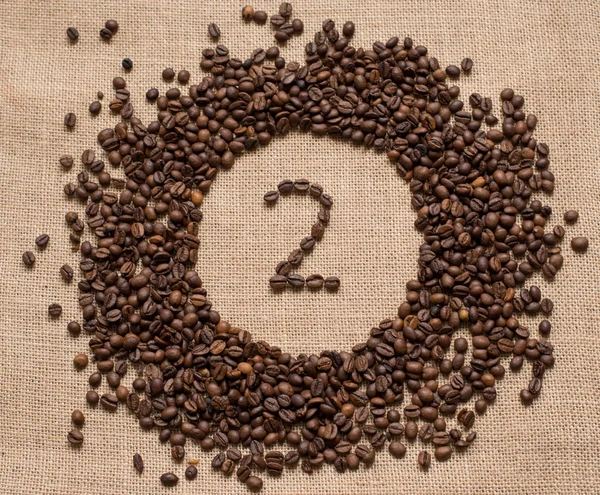 Numbers from coffee beans on burlap background — Stock Photo, Image