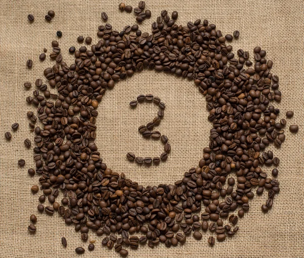 Numbers from coffee beans on burlap background — Stock Photo, Image