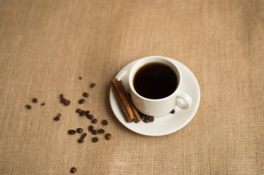 Kahve fincanı kahve çekirdekleri üzerine çuval bezi ile